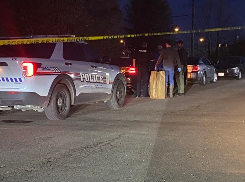 Coroner and police process crime scene behind Hobby Lobby in